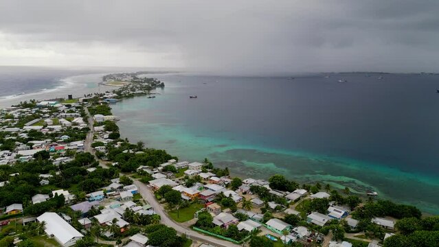 MARSHALL ISLANDS - 3.18.2024 - Great aerial view of houses on the coast of the Marshall Island as rain clouds come in.