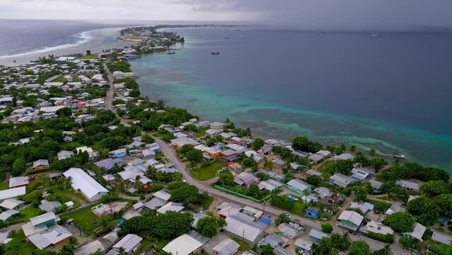 MARSHALL ISLANDS - 3.18.2024 - Great aerial panorama of houses on the coast of the Marshall Island as rain clouds come in.