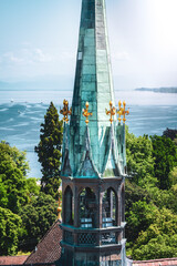 Blick auf den östlichen Kirchturm des Münsters unserer Lieben Frau sowie dem See an einem sonnigen Sommertag mit Bergpanorama. Konstanz, Bodensee, Baden-Württemberg, Deutschland, Europa.
