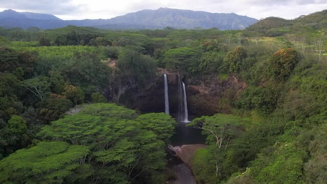 KAUAI - 3.19.2024 - Fantastic aerial footage moving over trees towards the Wailua Falls in Kauai, Hawaii.