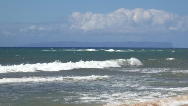 HAWAII - 3.19.2024 - Waves lap the shore of Ni‘ihau Island, Hawaii on a sunny day.