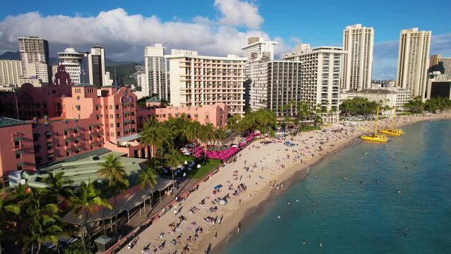 WAIKIKI - 3.19.2024 - Great aerial footage moving towards palm trees on the beach of Waikiki, Hawaii.