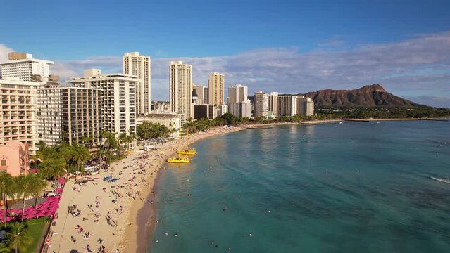 WAIKIKI - 3.19.2024 - Amazing aerial view approaching tourists on the beach in Waikiki, Hawaii.