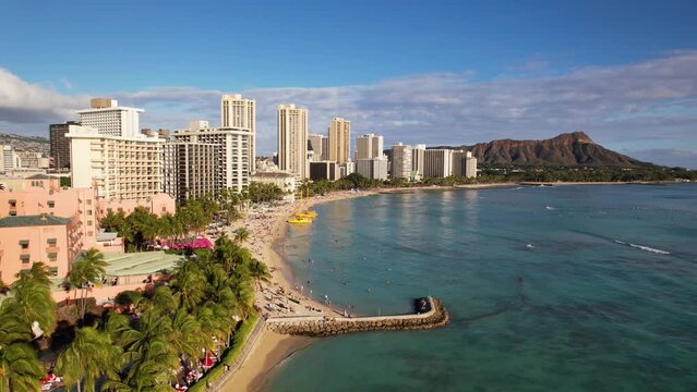 WAIKIKI - 3.19.2024 - Very good aerial footage moving up the coast of Waikiki, Hawaii, as waves roll towards the shore.