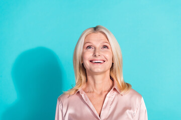 Portrait of pretty elegant lady look up empty space wear shirt isolated on turquoise color background