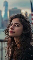 Obraz premium Latin woman looking at the horizon with the US flag in the background in the city. Happy latin woman contemplating the landscape full of hope for the future.