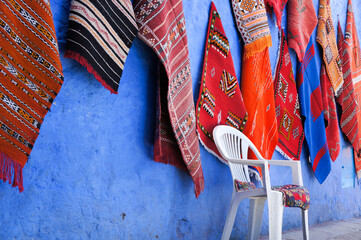 壁に掛けられたモロッコの伝統的な織物とイス