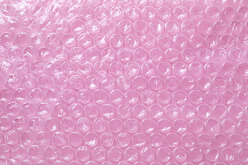 Transparent bubble wrap on pink background, top view