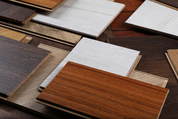 Many different samples of wooden flooring on table