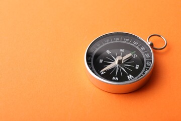 One compass on orange background, space for text. Tourist equipment