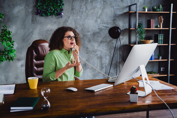 Photo of shocked lovely successful woman speaking listening news sitting in office workspace...