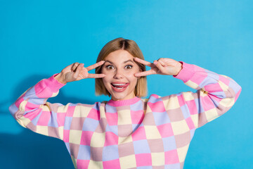 Fototapeta premium Photo portrait of pretty young girl show v-sign face posing wear trendy pink outfit isolated on blue color background