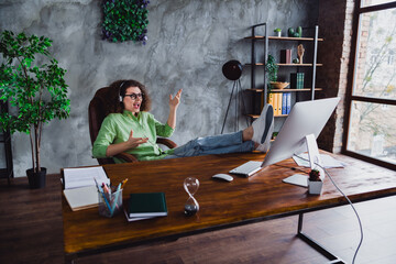 Photo of cheerful excited lovely woman speaking online listening customer sitting in modern office...