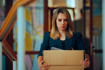Sad Office Employee Carrying her Stuff Being Fired. Upset businesswoman resigning from her corporate job 

