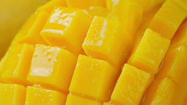 Slow Motion Shot of Mango Juice Splashing through Mango Cube Slices