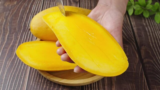 woman cutting ripe mango fruit