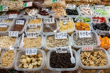 A variety of nuts and seeds are displayed in plastic containers food grain market sell