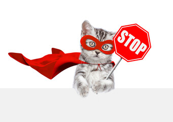 Cute kitten wearing superhero costume showing stop sign above empty white banner. Isolated on white background - 784889753