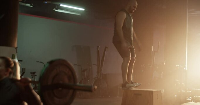 Strong man and crop woman training together in gym