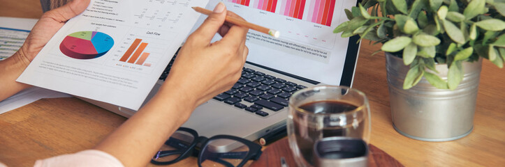 Banner woman working office desk reading financial report finance chart graph on table. Wide tax...
