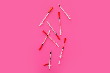 Empty syringes on pink background