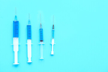Medical syringes with medicine on blue background