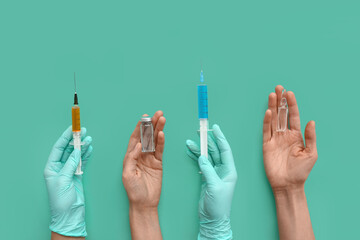 Hands in gloves holding syringes and ampoules on turquoise background
