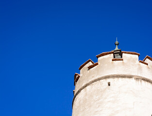 Background with part of the top of a tower on a blue sky