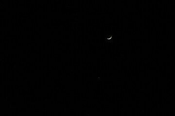 The waxing crescent moon in the dark night sky