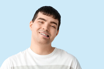 Young man on blue background, closeup. National Cerebral Palsy Awareness Month