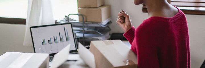 African american women raise arm to celebrate with happiness while checking online order on laptop