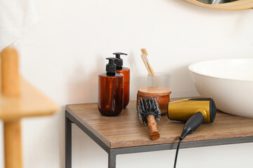 Round brush with hair dryer on table in bathroom, closeup