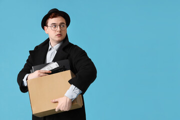 Male spy with gun in box on blue background