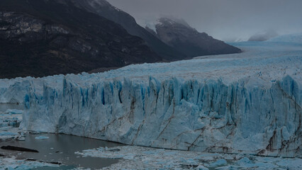 The amazing Perito Moreno Glacier stretches between the mountains to the horizon. A mass of blue...