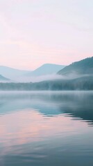 Fototapeta premium A body of water with towering mountains in the background under a clear sky, creating a scenic landscape view.
