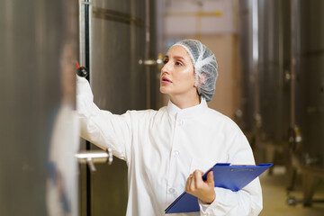 Female scientist examines in a food and beverage manufacturing factory.