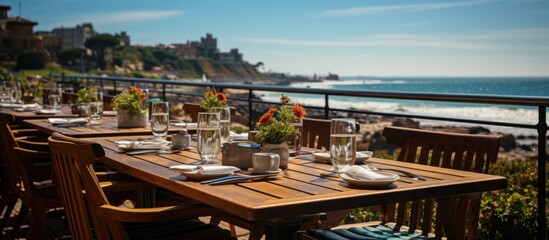 Tables in a restaurant with food and drinks on the seafront - obrazy, fototapety, plakaty