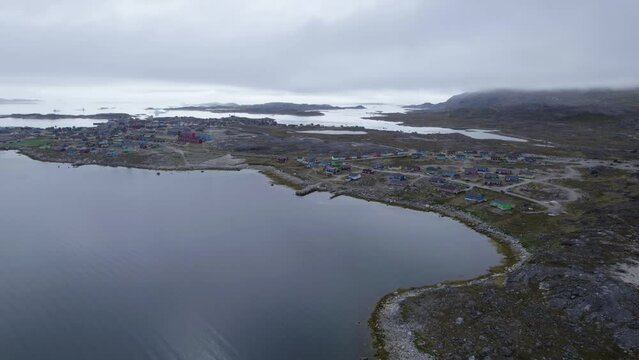 Greenland Nanortalik Village Remote Fishing Town Drone High Angle. Cruise Destination Adventure Misty Cloudy Mountains in Norwegian Fjord.