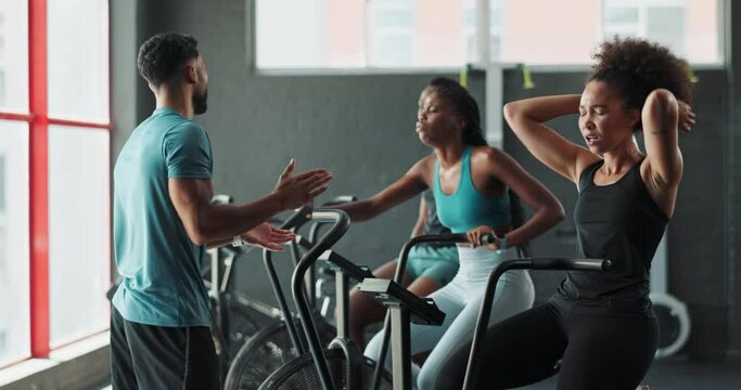 Coach, high five or people on cycling machine for a biking workout or cardio training for endurance. Fitness class, gym goals or woman on exercise bike with personal trainer for support or motivation