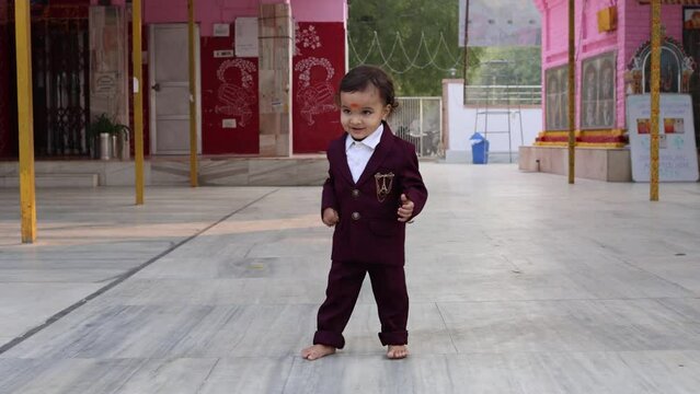 cute indian toddler walking in suit at outdoor from different angle