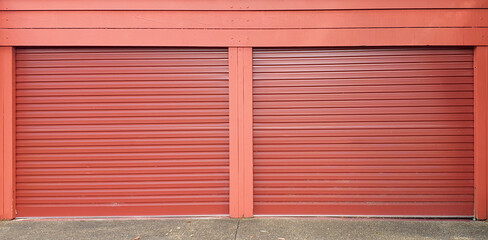 two single rust color garage doors corrugated metal against red wall