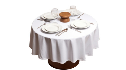 A round table with a white cloth, dinner plates and silverware on top