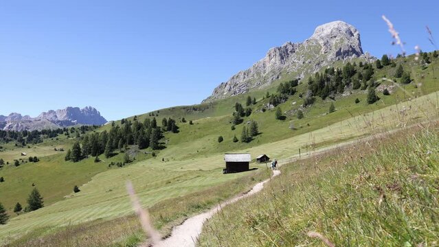 Open-air footpath among green meadows of Sas de Putia - Peitlerkofel in South Tyrol, Italy. High quality 4k footage