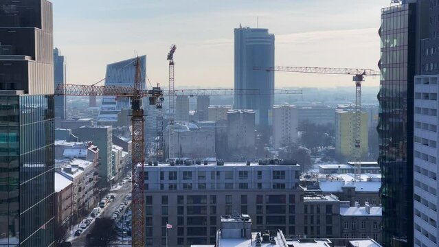 Winter Cityscape with Cranes Over Warsaw. Snowy Urban View and Construction