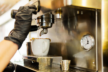 Fototapeta na wymiar A barista is making coffee in a coffee machine