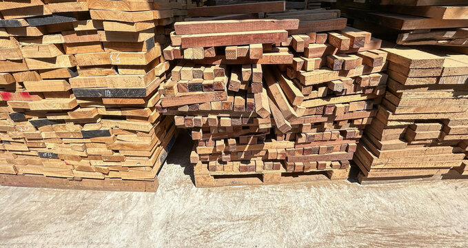 Lumber planks stack in the sawmill.  Stacked of woods on ground in furniture factory