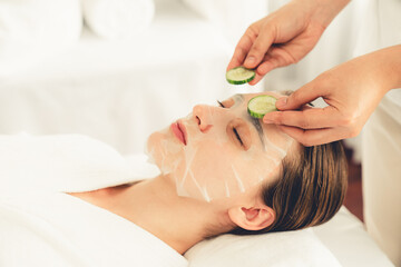 Obraz na płótnie Canvas Serene daylight ambiance of spa salon, woman customer indulges in rejuvenating with luxurious cucumber facial mask. Facial skincare treatment and beauty care concept. Quiescent