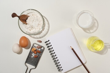 Flat lay collection of utensils and ingredients for home cooking with flour, oil, egg, milk and...