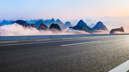 Asphalt highway road and karst mountain with fog natural landscape at sunrise