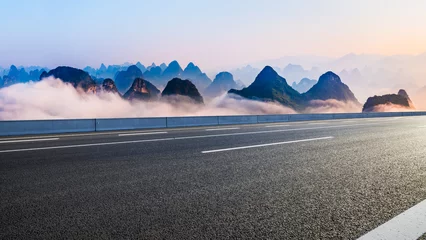 Poster Asphalt highway road and karst mountain with fog natural landscape at sunrise © ABCDstock